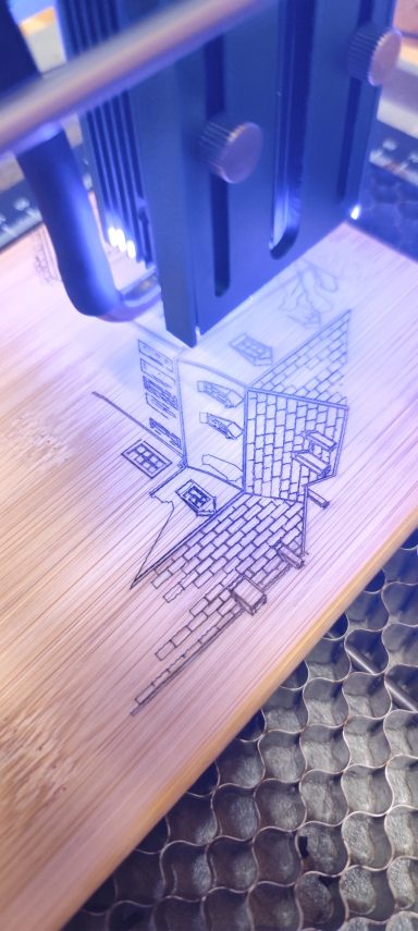 Lasergravur auf Holz mit geometrischen Mustern und Lichtquelle.